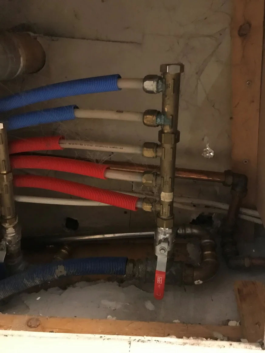 Brugsvandsinstallation med blandede rørmaterialer og begyndende tæring ved fordelerrør