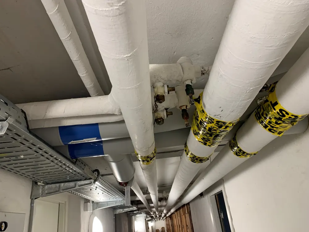 Rørføring og varmeinstallation i kælder under boligforening